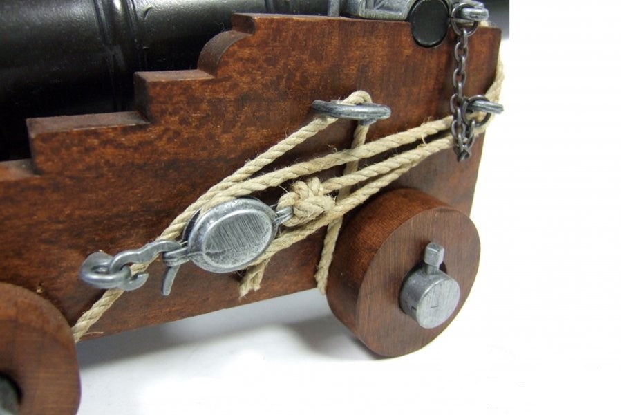 Wooden model of a cannon with metal components and rope on a white background