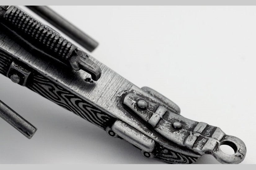 Close-up of a metallic object with intricate design on a light gray background
