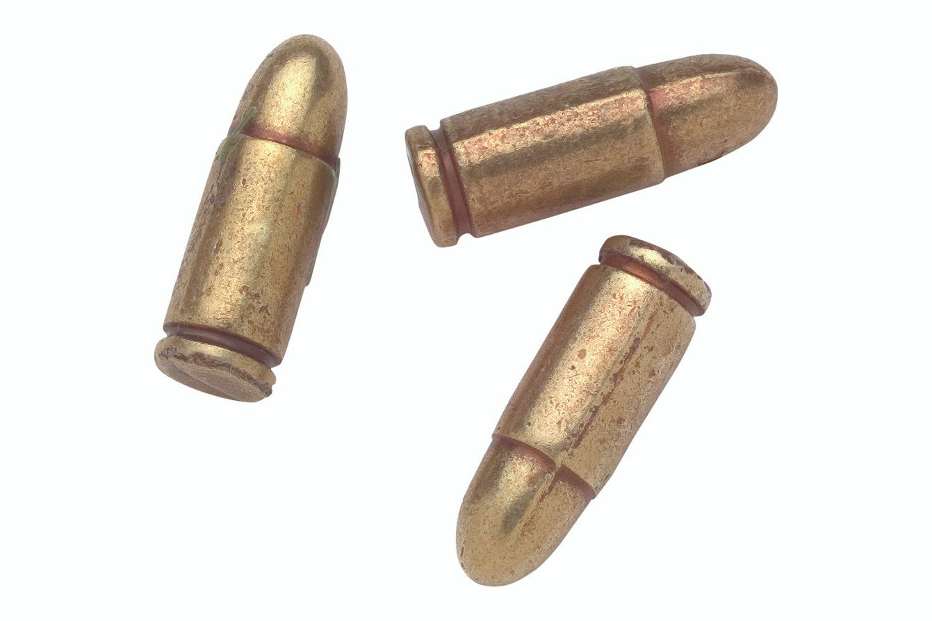 Three brass bullets on a white background