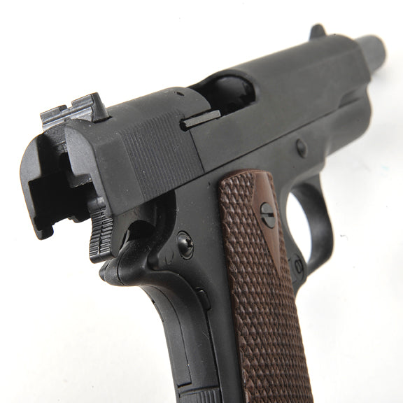 Rear view of non firing 45 Gov’t M1911 military pistol replica showing grip and hammer
