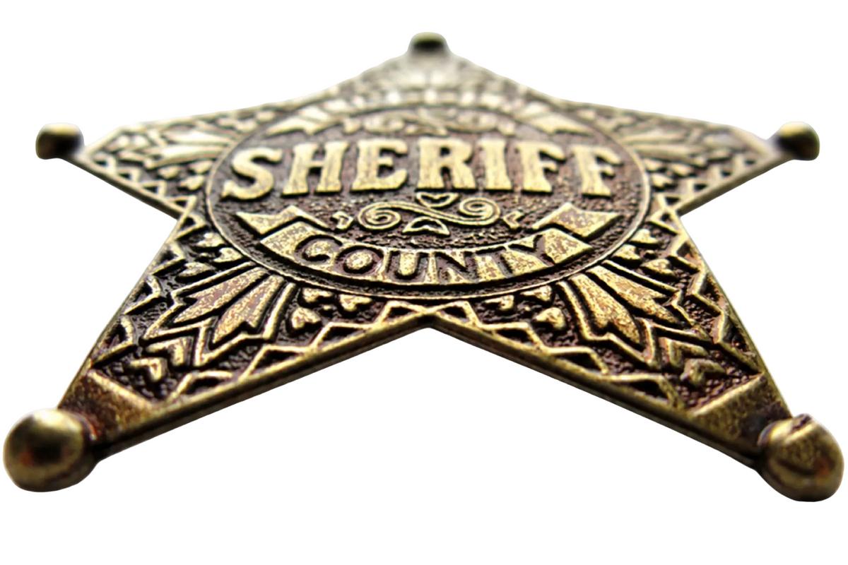 Denix 104 Lincoln County sheriff badge in antiqued brass, low-angle front view showing raised lettering