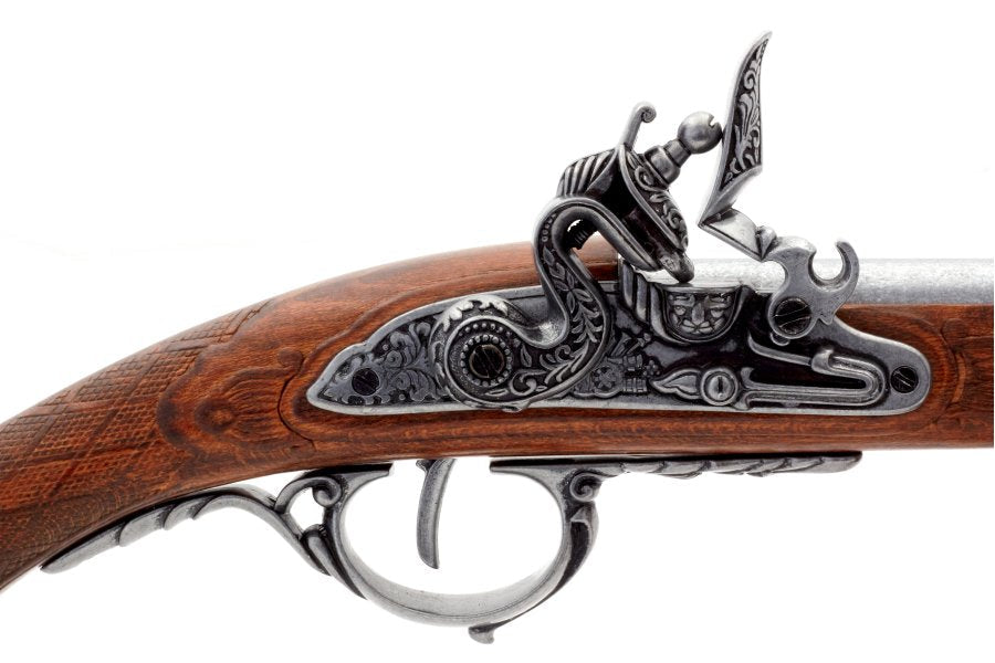 Close-up of a detailed flintlock gun with ornate design on a white background, featuring the Denix brand.