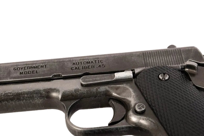 Close-up of a Government Model automatic pistol with 'Denix' branding.