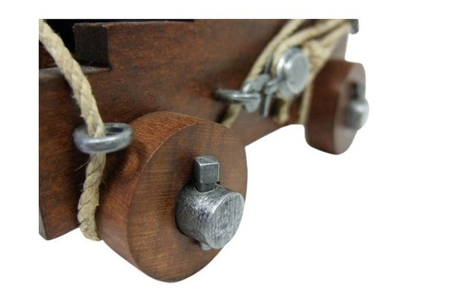 Close-up of a wooden object with metal components and rope on a white background