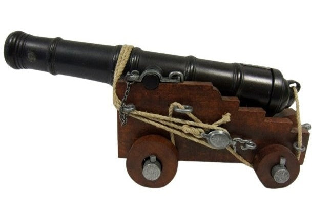Model cannon on a wooden carriage with a white background