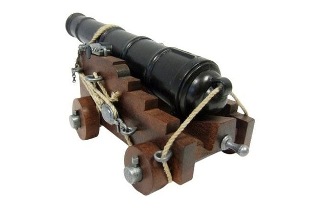 Model cannon on wheels with a wooden base on a white background