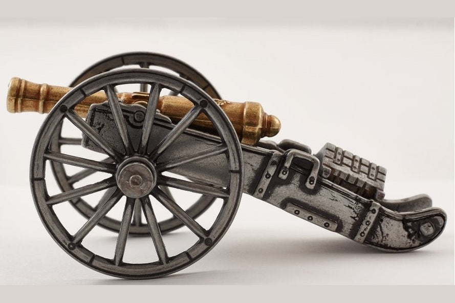 Model of a cannon on wheels with a white background
