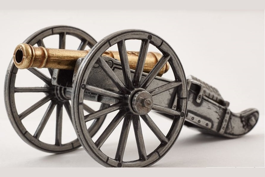 Model cannon with large wheels on a white background